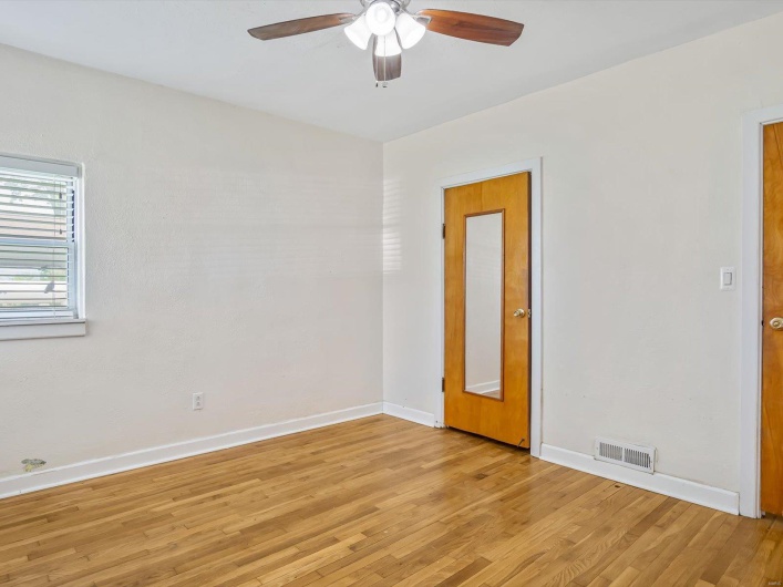 Spare room featuring baseboards, visible vents, ceiling fan, and light wood finished floors