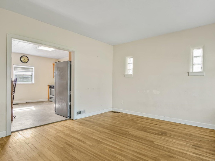 Spare room with visible vents, light wood-style flooring, and baseboards