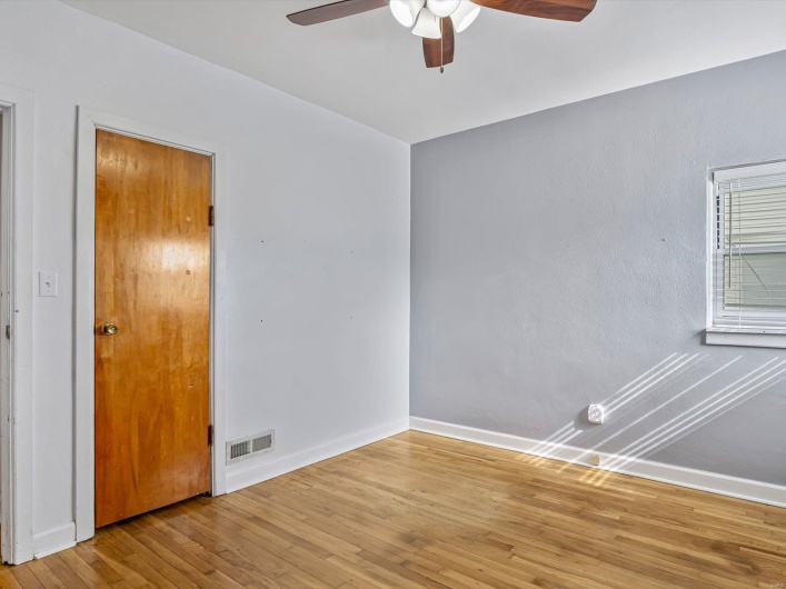 Empty room with visible vents, ceiling fan, hardwood / wood-style floors, and baseboards