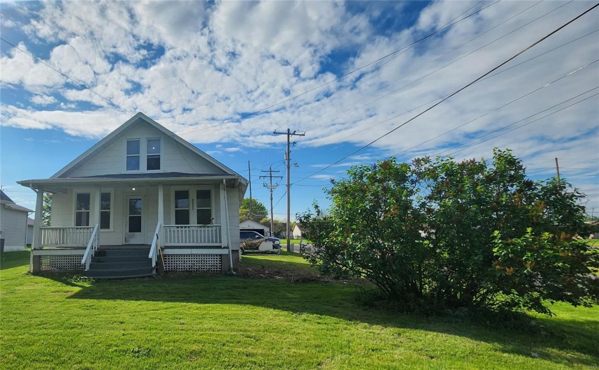 View of front facade with a porch and a front lawn