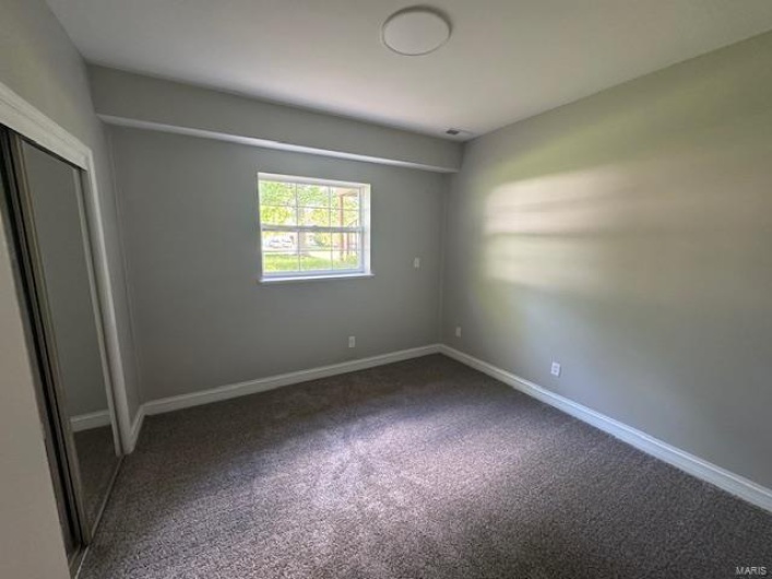 Unfurnished bedroom featuring carpet floors, baseboards, and a closet