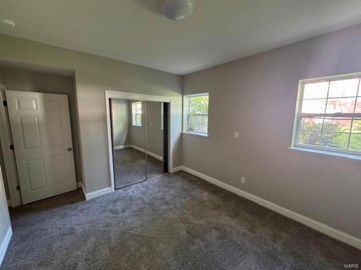 Unfurnished bedroom with carpet floors, baseboards, and a closet