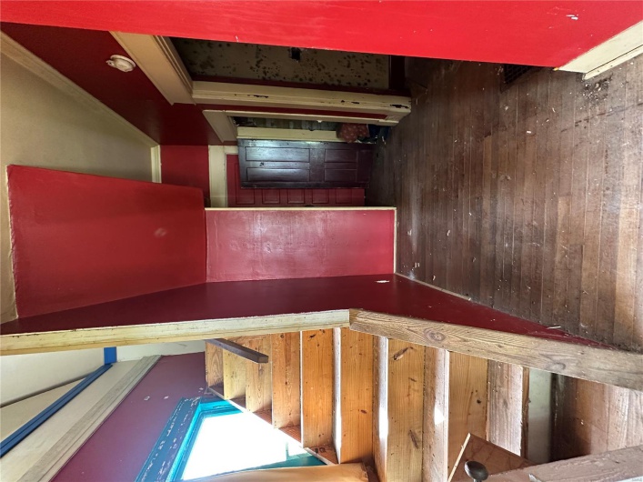Stairway featuring crown molding and hardwood / wood-style floors