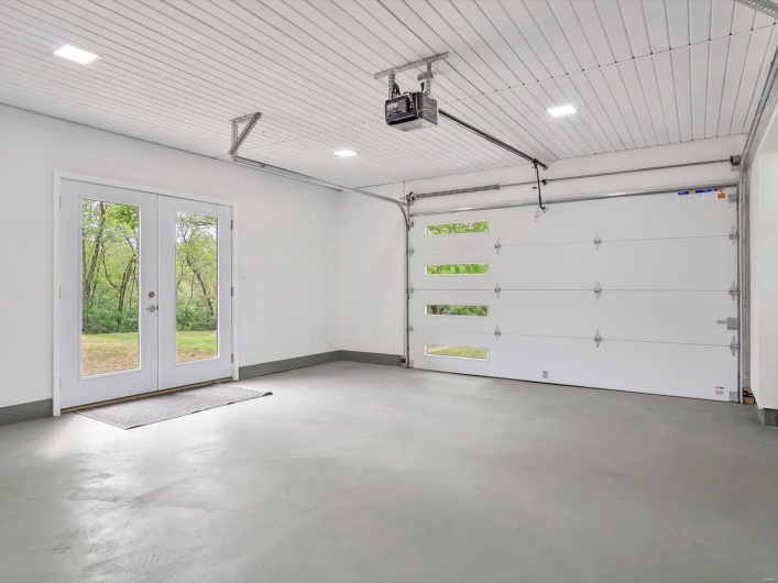 Garage featuring a garage door opener, french doors, and baseboards