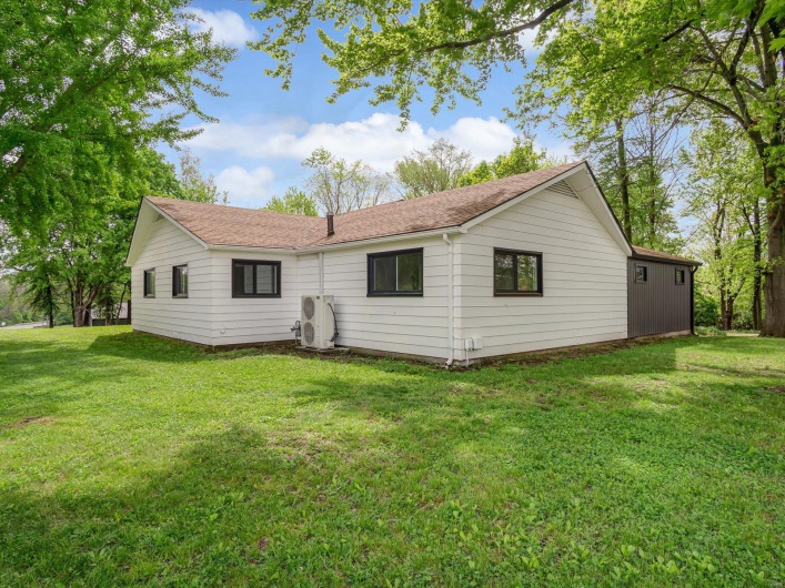 Back of house featuring a yard and ac unit