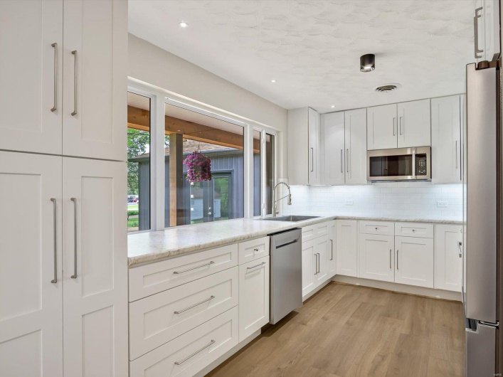 Kitchen featuring tasteful backsplash, a sink, appliances with stainless steel finishes, and white cabinetry