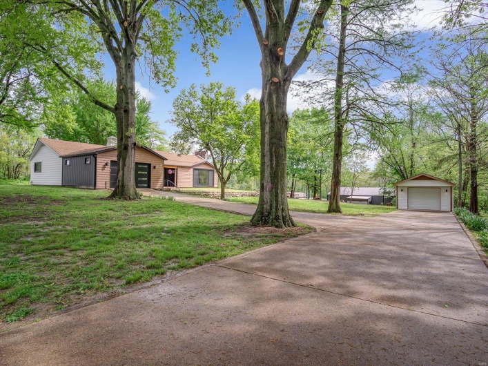 View of yard with an outbuilding, driveway, and a garage