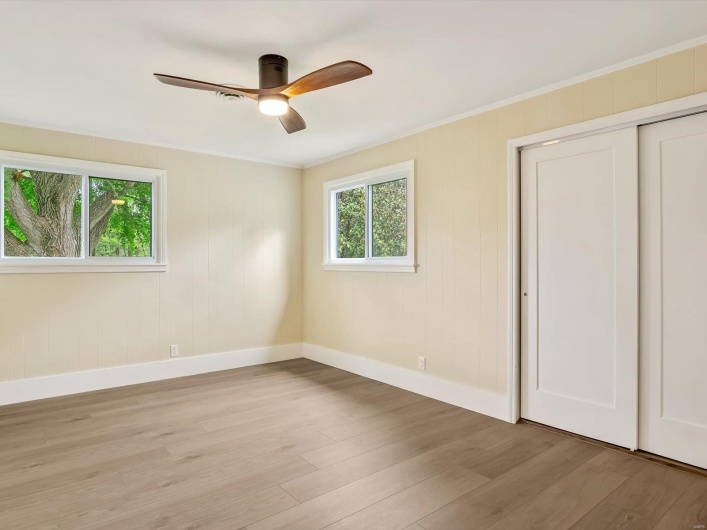 Unfurnished bedroom with baseboards, light wood-style floors, and crown molding