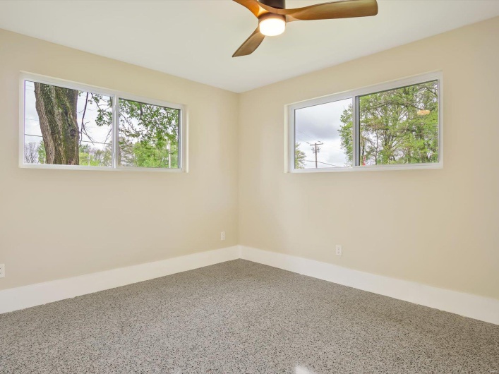 Unfurnished room with baseboards, a ceiling fan, and speckled floor