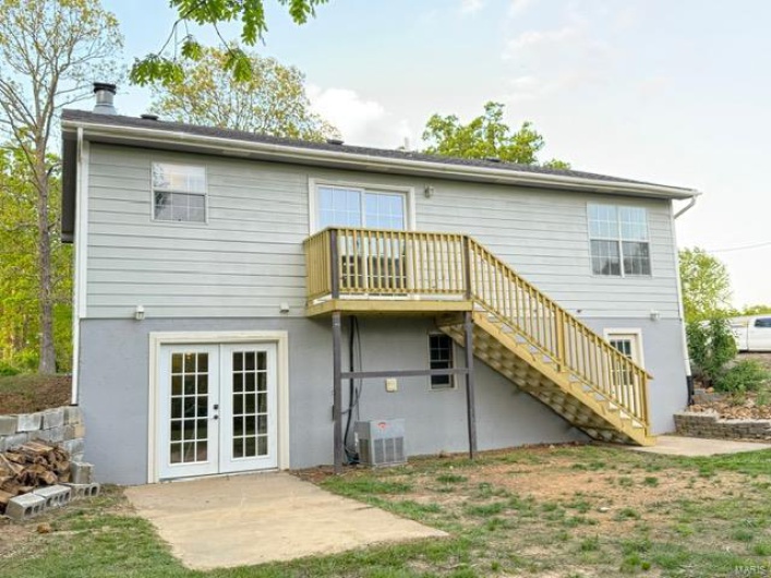 Rear view of house featuring french doors, a wooden deck, a patio area, central AC, and stairs