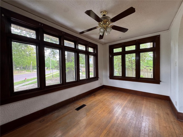 Spare room with baseboards, plenty of natural light, a textured ceiling, and visible vents