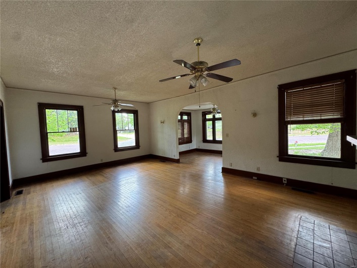 Spare room featuring arched walkways, a textured ceiling, ceiling fan, and hardwood / wood-style floors