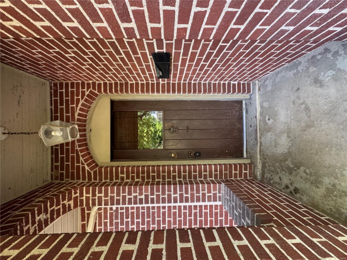 Doorway to property featuring brick siding