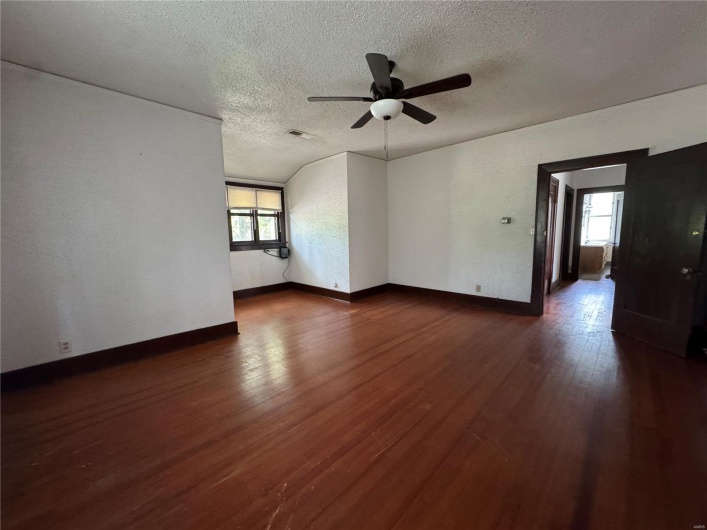Unfurnished living room with a ceiling fan, a textured ceiling, visible vents, and plenty of natural light