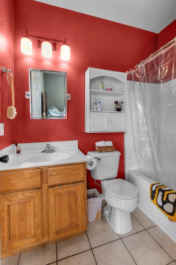Full bath with vanity, tile patterned floors, toilet, and shower / tub combo with curtain
