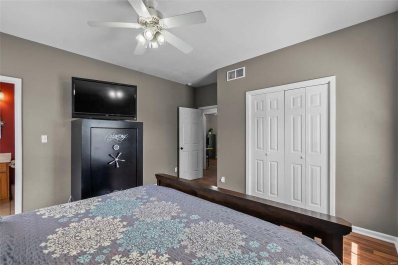 Bedroom featuring visible vents, a closet, lofted ceiling, wood finished floors, and a ceiling fan
