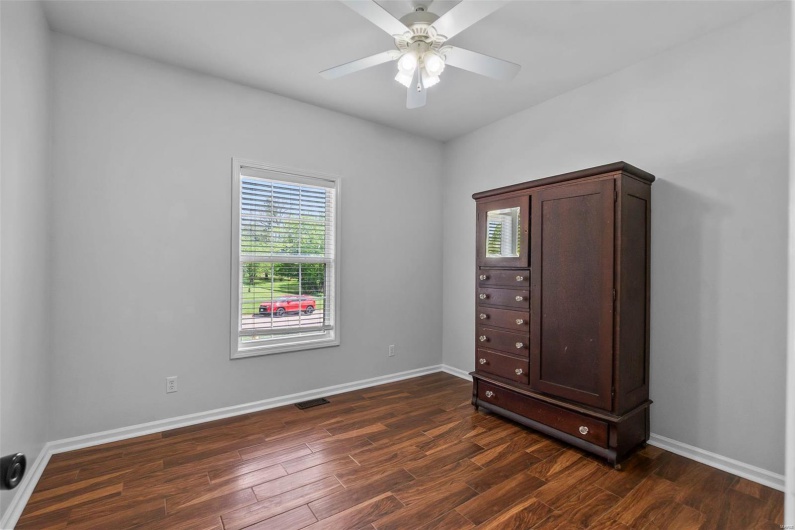 Unfurnished bedroom with baseboards, a ceiling fan, dark wood finished floors, and visible vents