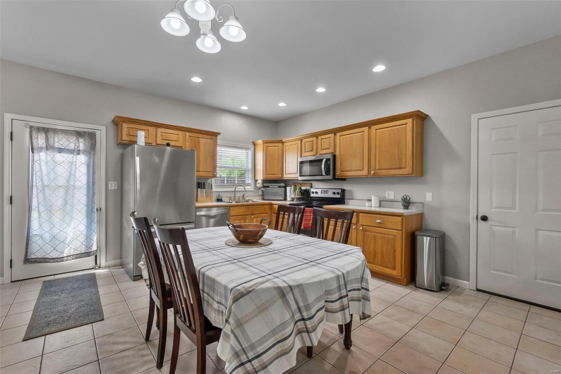 Kitchen featuring a sink, light countertops, baseboards, stainless steel appliances, and light tile patterned flooring