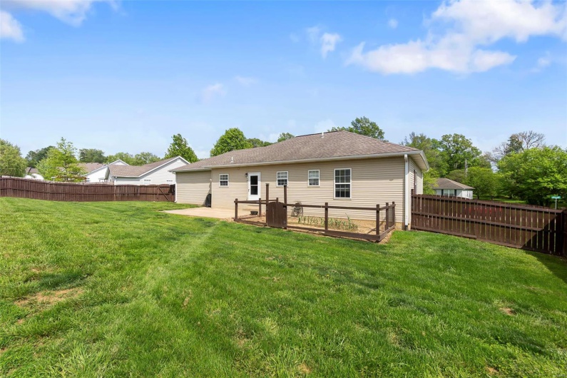 Rear view of house featuring a lawn and a fenced backyard