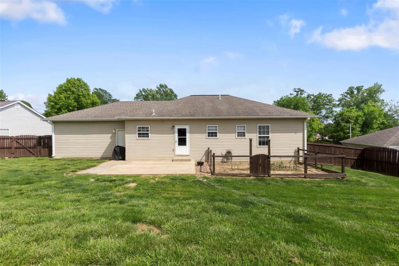 Rear view of property featuring a lawn, a fenced backyard, and a patio area