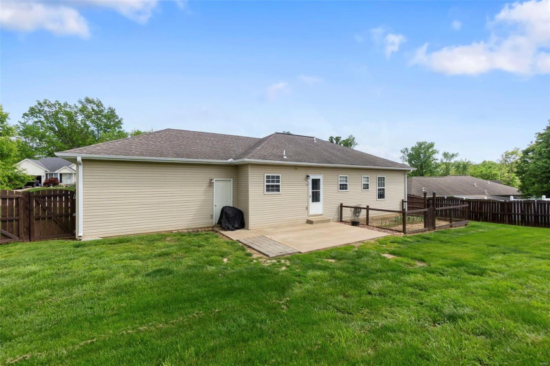 Back of property with a yard, a patio, a gate, and a fenced backyard
