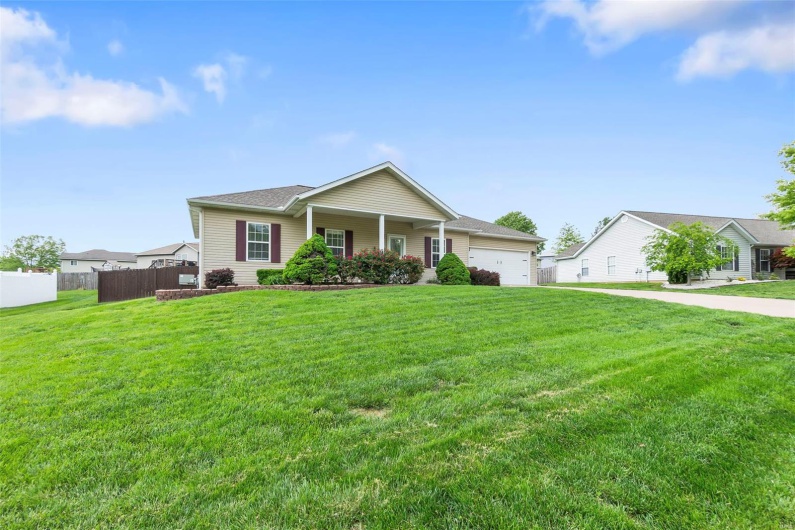 Ranch-style house with fence, a front lawn, and a garage