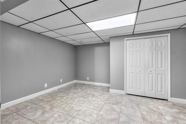 Finished below grade area with baseboards and a paneled ceiling