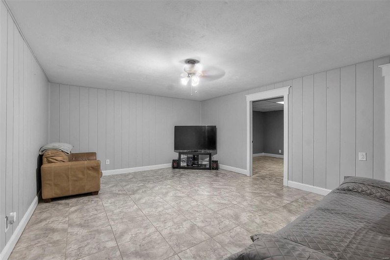 Living area with baseboards, a ceiling fan, and a textured ceiling