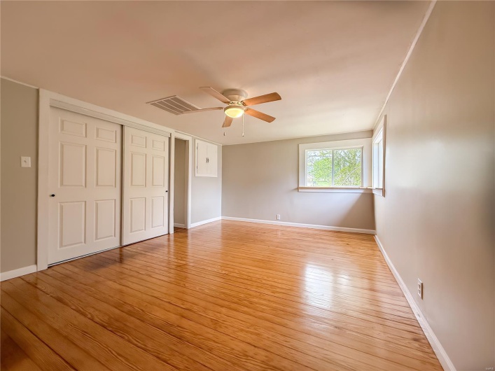 Unfurnished bedroom with visible vents, a closet, baseboards, ceiling fan, and light wood finished floors