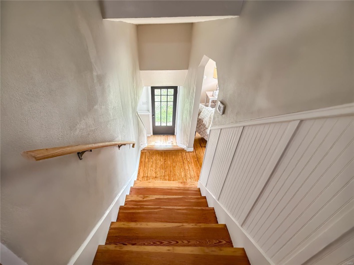 Stairs featuring a high ceiling and wood finished floors