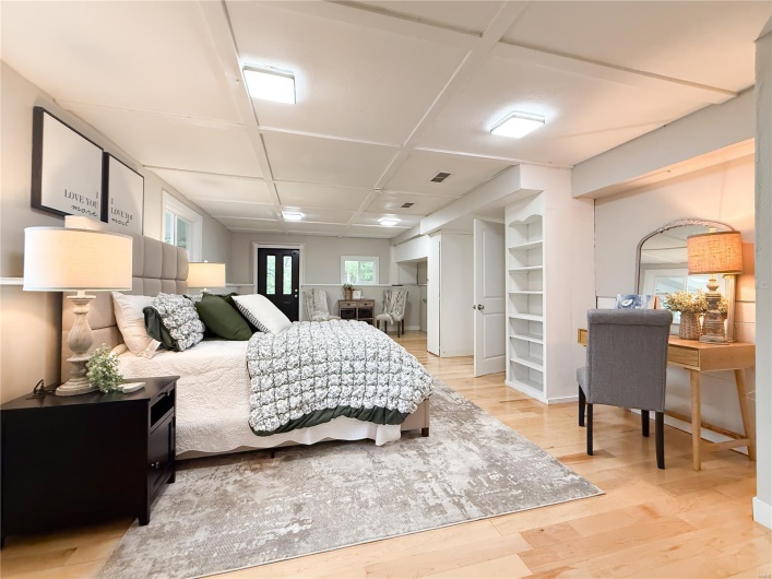 Bedroom with coffered ceiling, visible vents, and light wood-type flooring