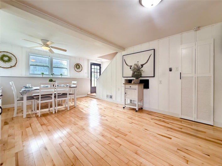 Living area featuring light wood-style floors, ceiling fan, and visible vents