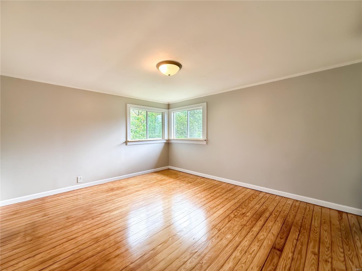 Empty room with crown molding, baseboards, and light wood-style flooring