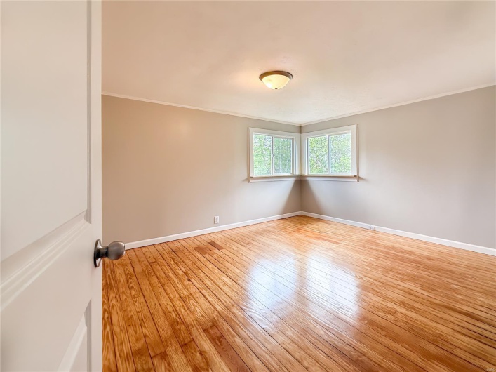 Unfurnished room with crown molding, baseboards, and hardwood / wood-style floors