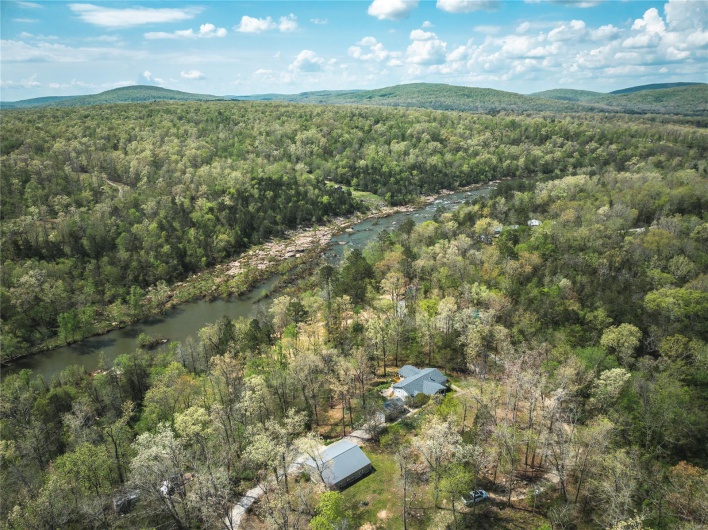 Aerial view featuring a wooded view and a mountain view