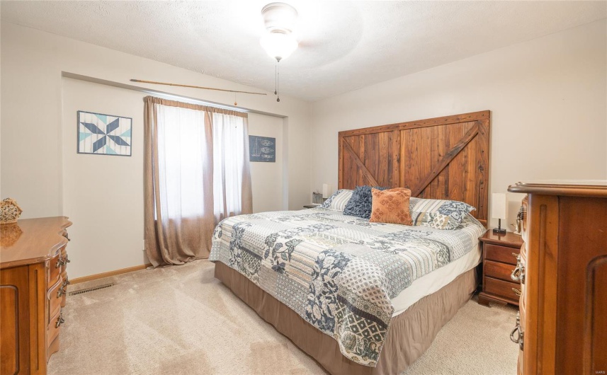 Bedroom with light colored carpet, a ceiling fan, and baseboards