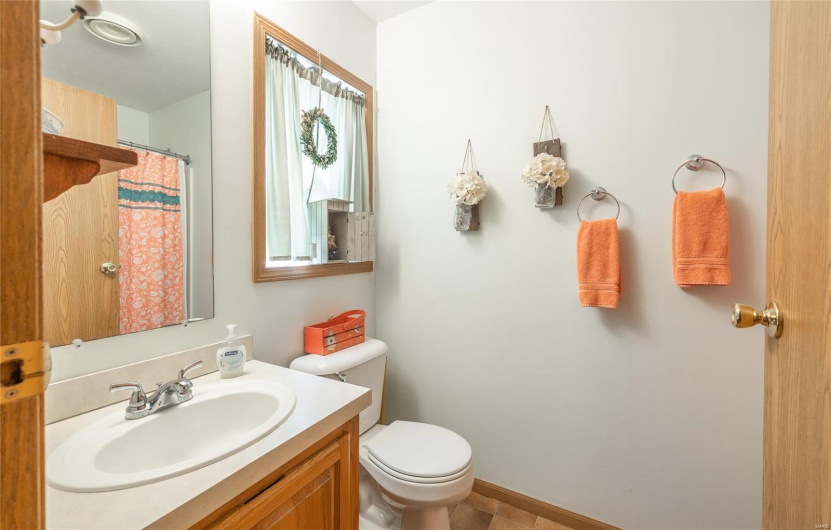 Bathroom featuring toilet, curtained shower, and vanity
