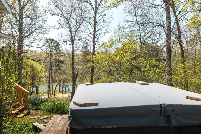View of yard featuring a view of trees and a hot tub