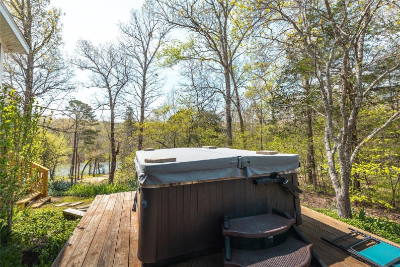 Deck with a wooded view and a hot tub
