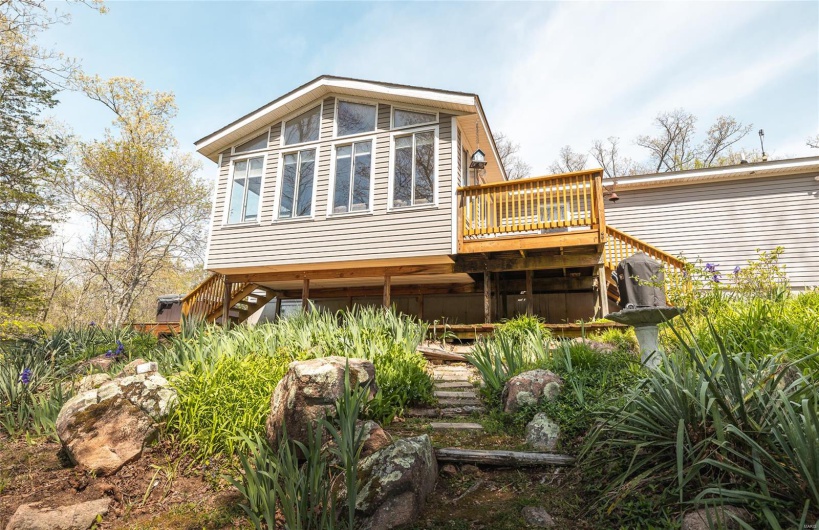 Rear view of house featuring a deck and stairs