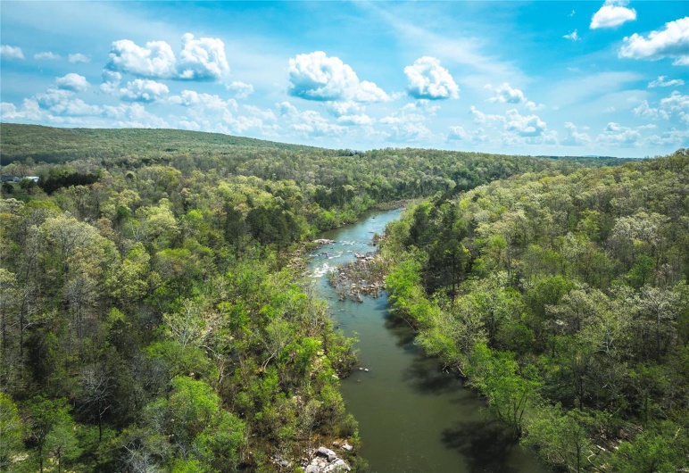 Aerial view featuring a wooded view and a water view