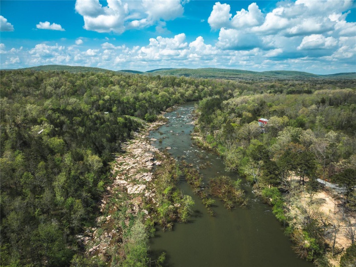 Birds eye view of property with a wooded view