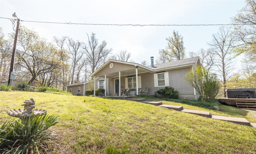 View of front of home with covered porch and a front yard