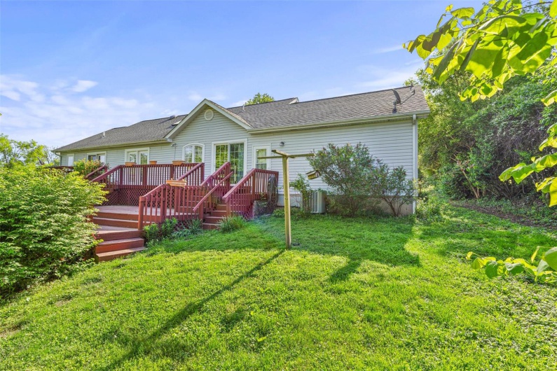 Back of property with a yard and a deck