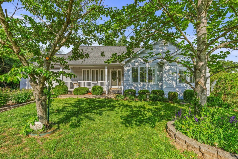 Front of house with a yard, a shingled roof, and a porch