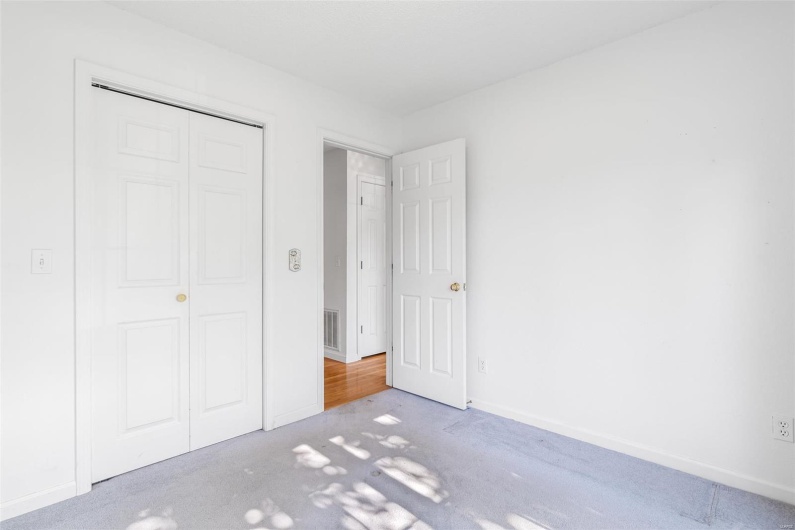 Bedroom with carpet floors, baseboards, visible vents, and a closet