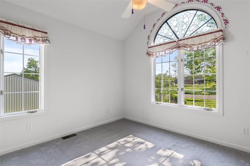 Bedroom with baseboards, a ceiling fan, lofted ceiling, and visible vents