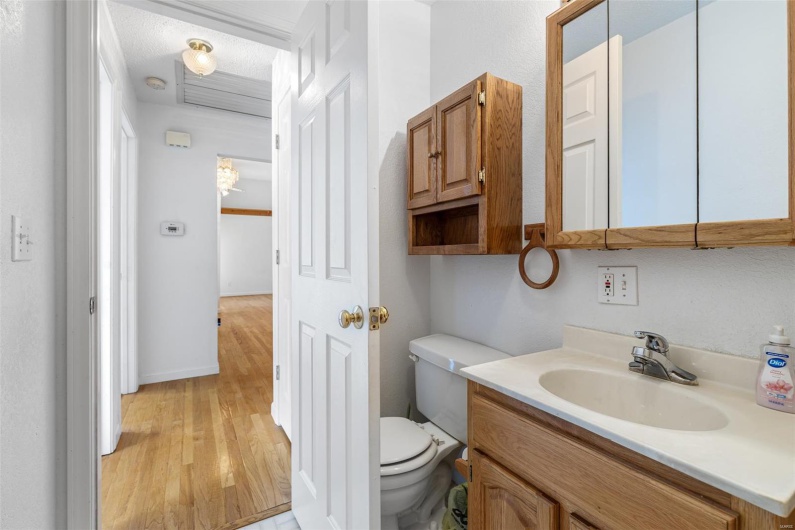 Bathroom featuring toilet, wood finished floors, and vanity