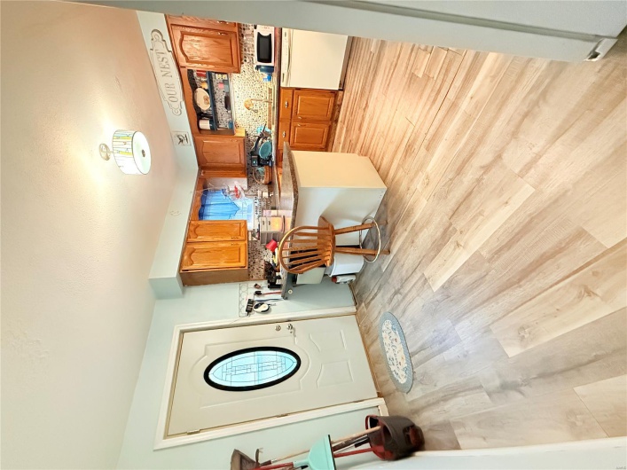 Kitchen with backsplash, dishwasher, light wood finished floors, a sink, and a peninsula