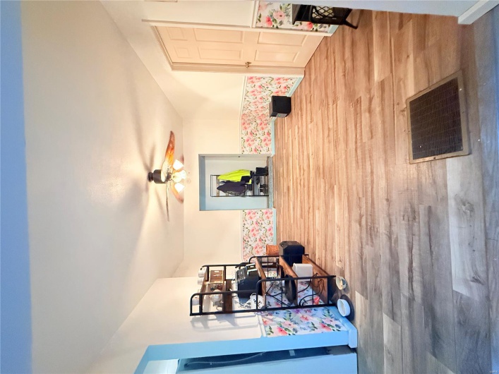 Living area featuring wood finished floors, ceiling fan, visible vents, and baseboards